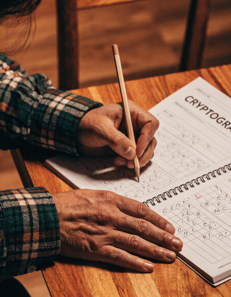 Person solving a cryptogram puzzle from one of our premium puzzle books