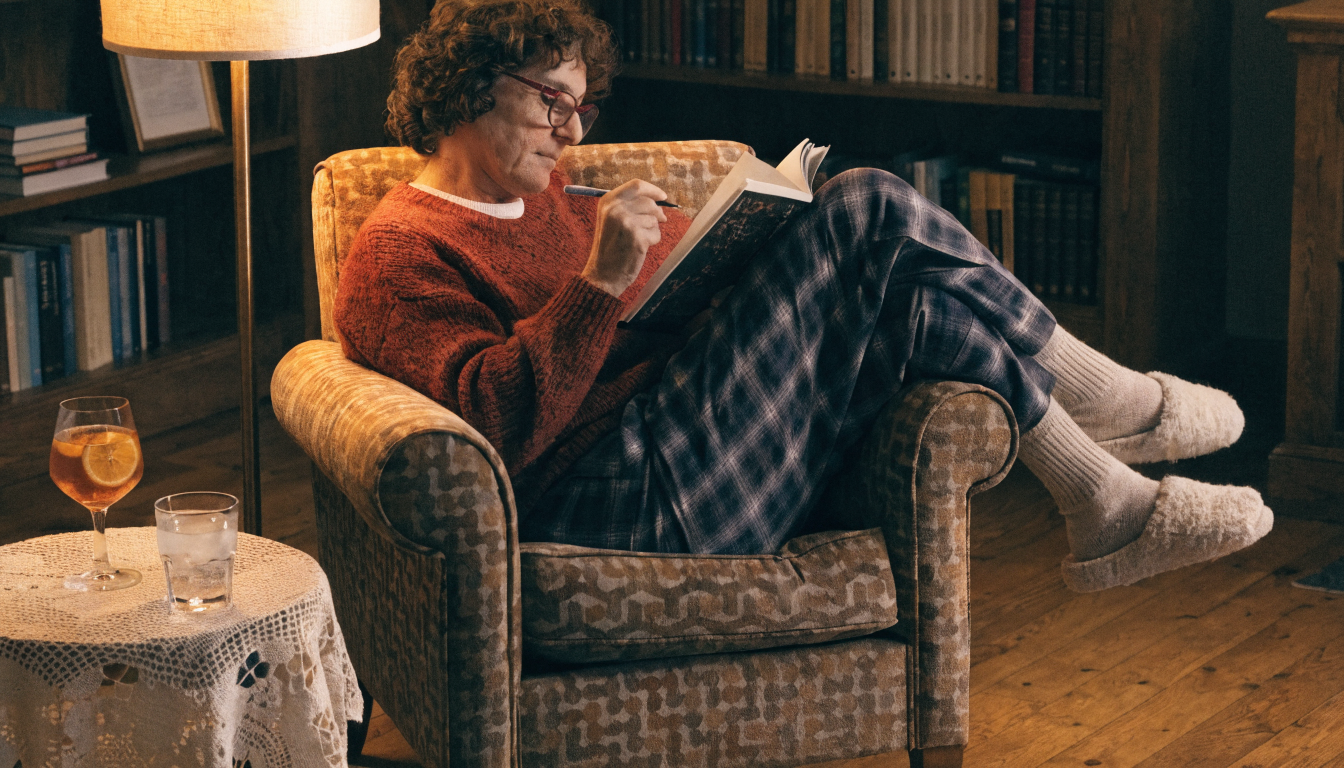 Adult enjoying a cryptogram puzzle book with a cup of coffee in a cozy reading spot